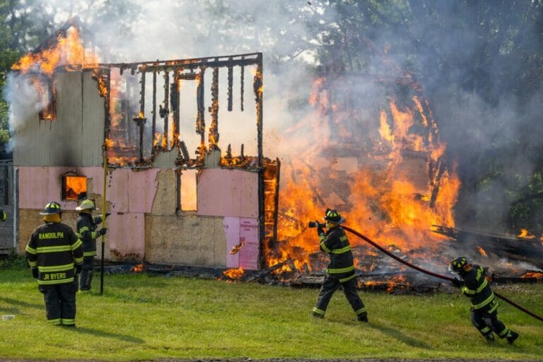 Fireman in front of a burning house.