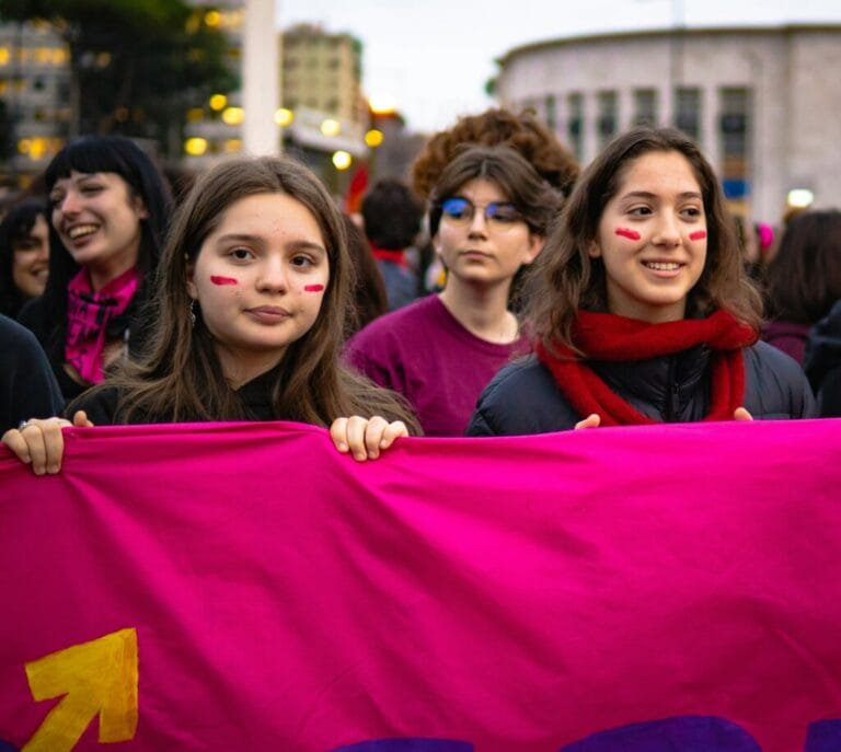 Women marching behind a banner