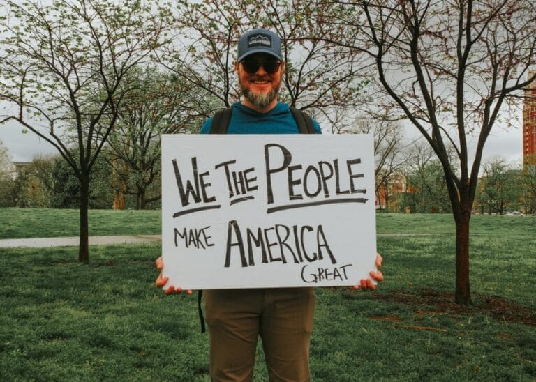 Person holding "We the People" sign